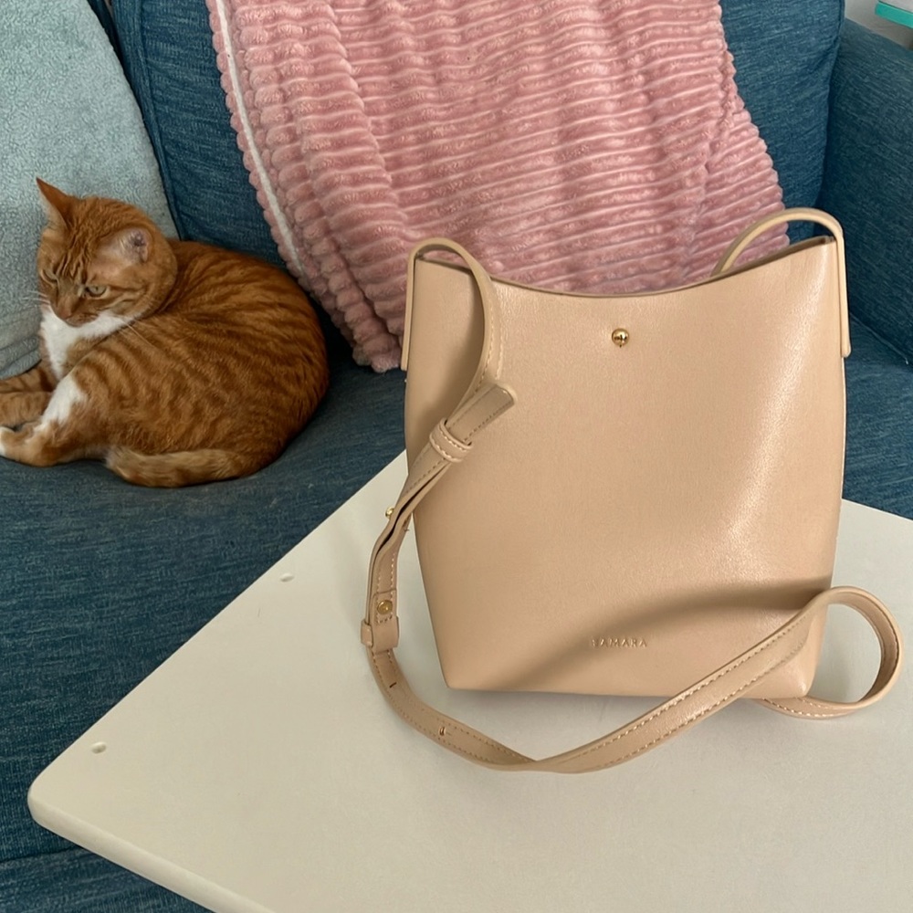 Tan triangle handbag, able to fits lots, but no inside pockets.